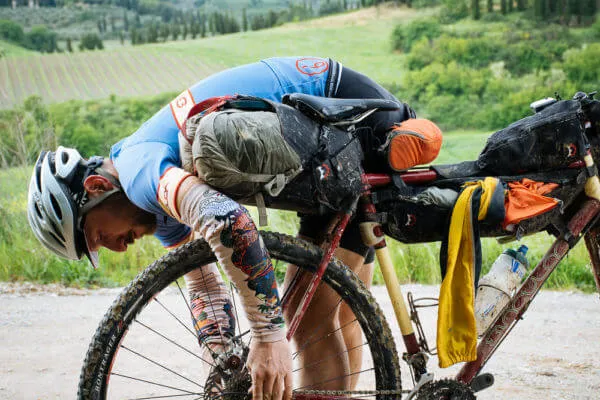 Un rider piegato sul manubrio, stremato