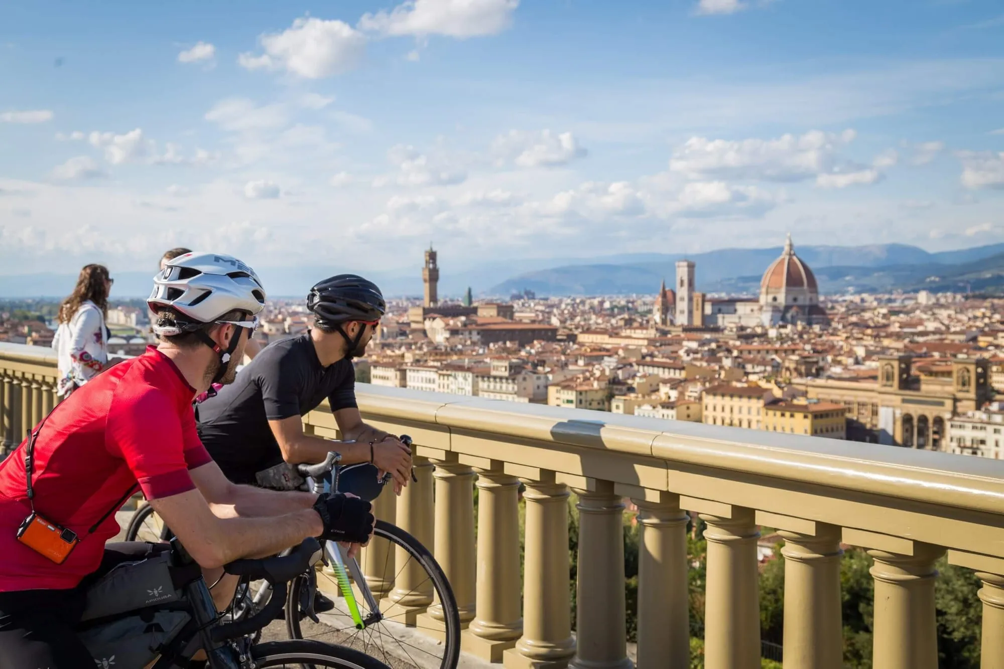 Due ciclisti affacciati su Firenze dal piazzale, con la cupola sullo sfondo