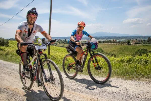 Due rider sorridenti su una strada bianca