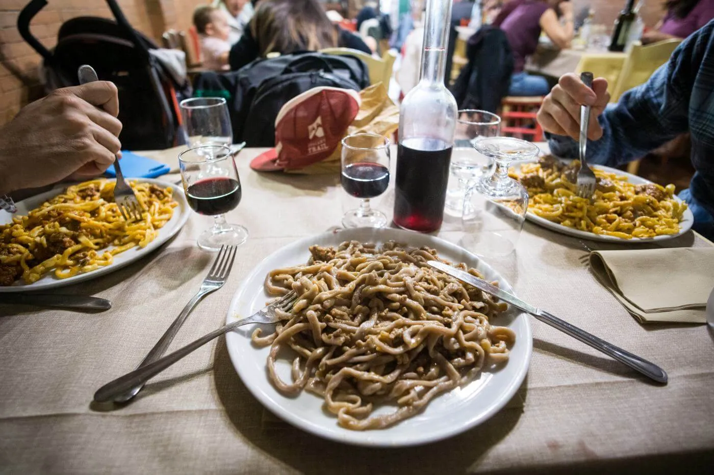 Un piatto di pasta e un bicchiere di vino in tavola