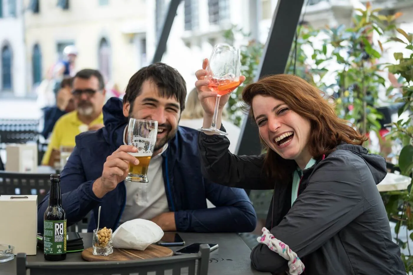 Due persone brindano al tavolino di un bar