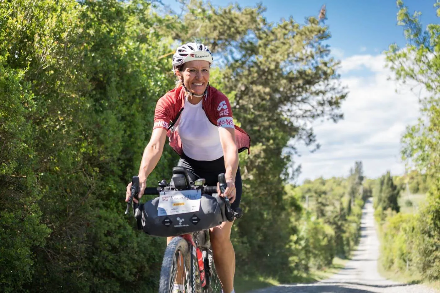 Un rider in salita fra i cipressi