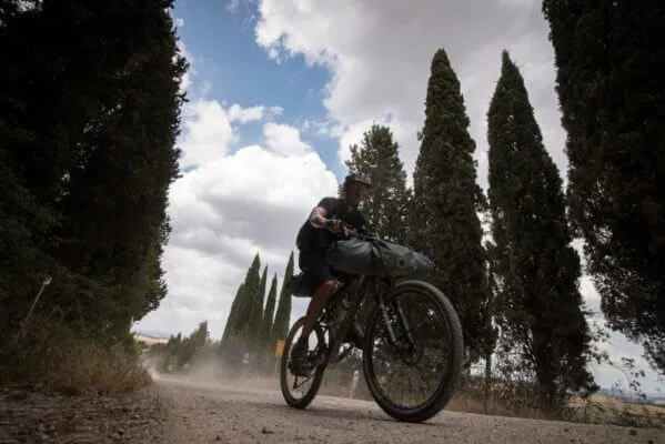 Un rider controluce fra i cipressi
