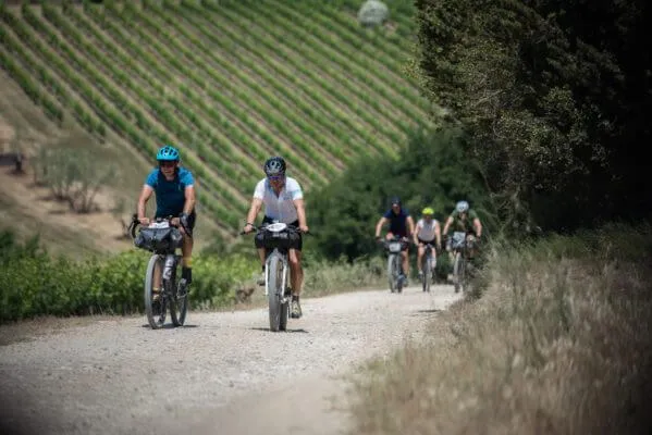 Un gruppo di rider su uno sterrato fra i vigneti